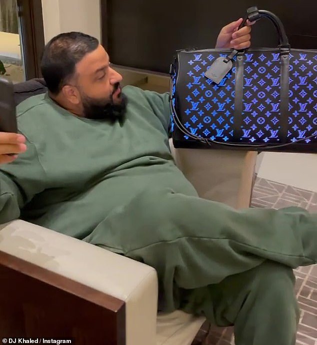 Mobile app: 'So, check this out, that's the app.  I always wanted this bag and my beautiful queen got me this as a gift, '' said DJ Khaled carrying a mobile app while wearing an olive green track suit.
