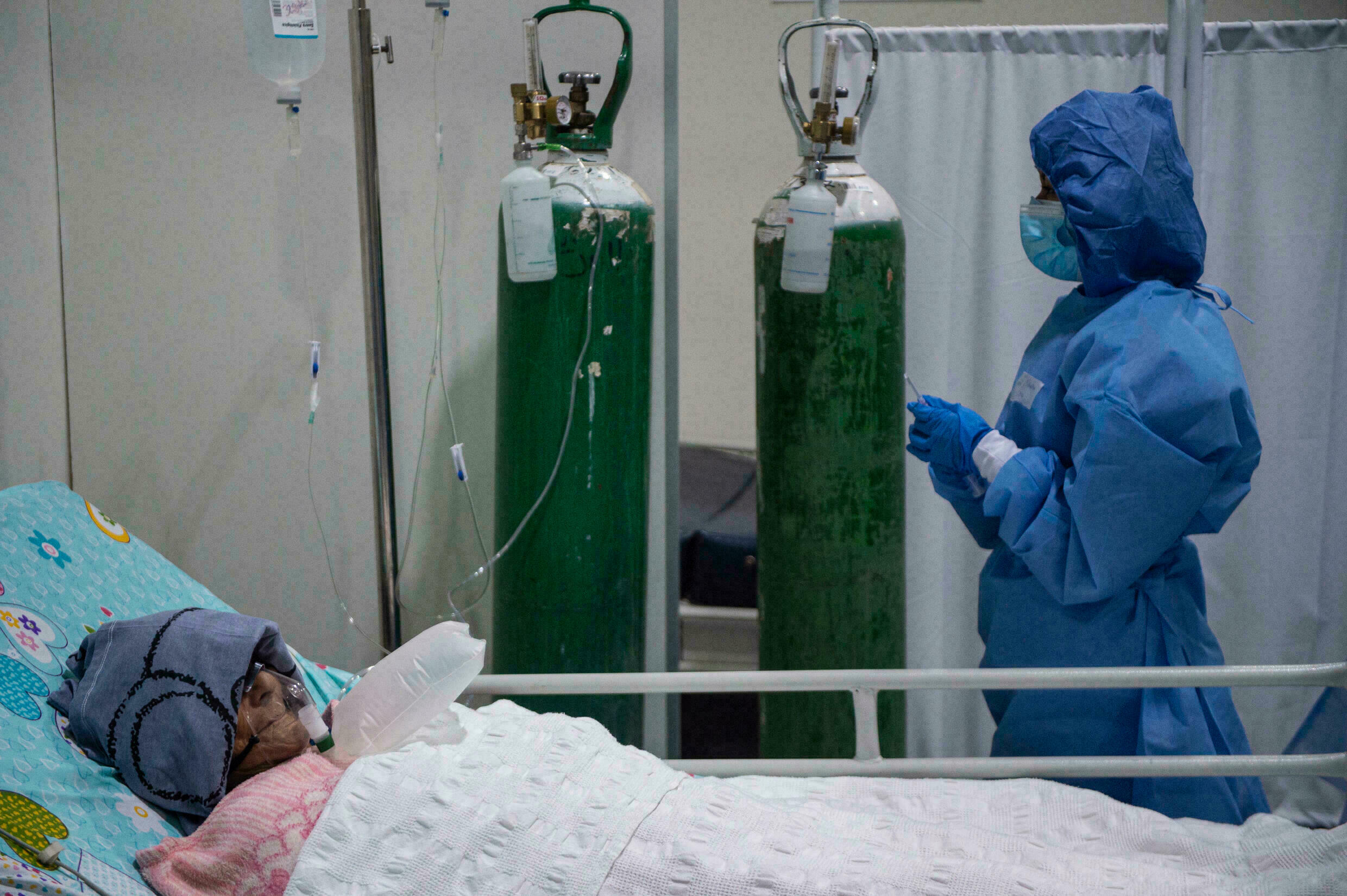 Um cuidador cuida de um paciente com Covid-19 na unidade de terapia intensiva do Hospital Virgen de Fatima em 19 de outubro de 2021 em Sullana, Peru