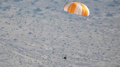 a sample space capsule parachuting to Earth in a test