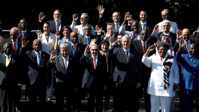Os líderes dos países do G77 tiram uma foto de grupo, levantando as mãos no ar.