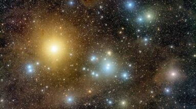 An image of the Hyades star cluster shows tons of glimmering spots against the dark backdrop of space. Toward the left is a very bright region and in the middle is a less bright, albeit significant, glowing section.