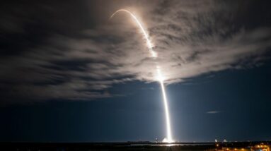 a spacex falcon 9 rocket launches into a night sky.