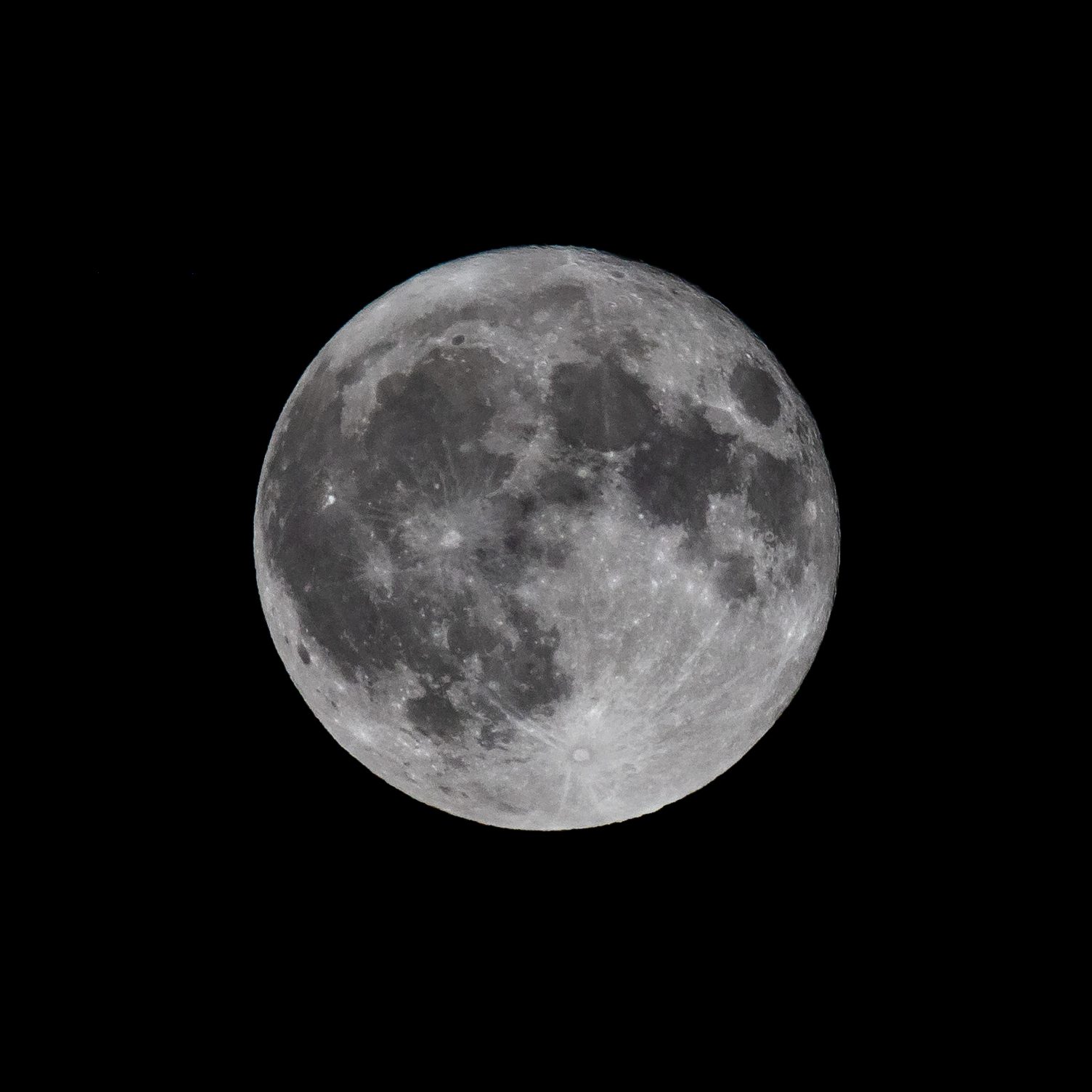 Lua totalmente iluminada no fundo preto do céu noturno.